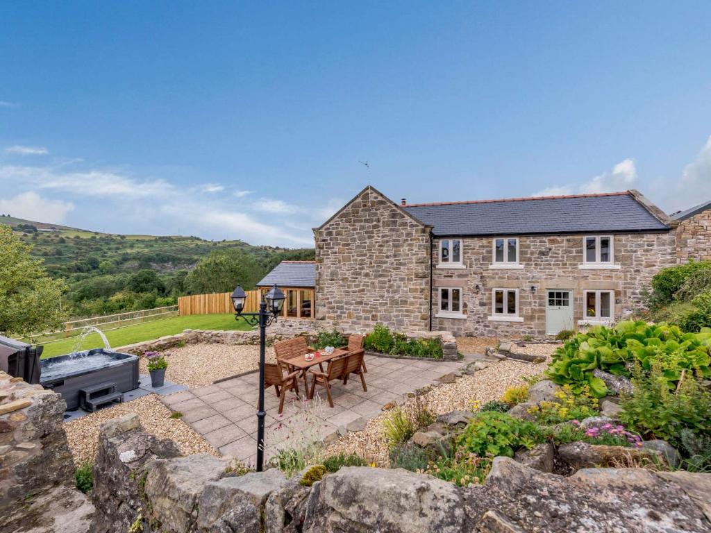 uma casa de pedra com um pátio e um grelhador em 3 Bed in Gwynfryn 83938 em Coedpoeth