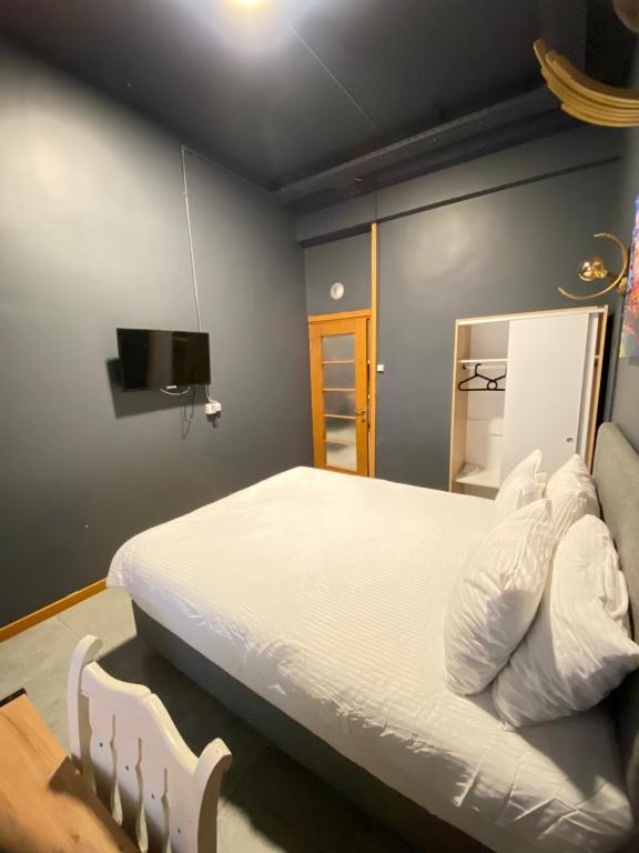 een slaapkamer met een bed en een tv aan de muur bij Unique Suite - On the Kadıköy seaside in Istanbul