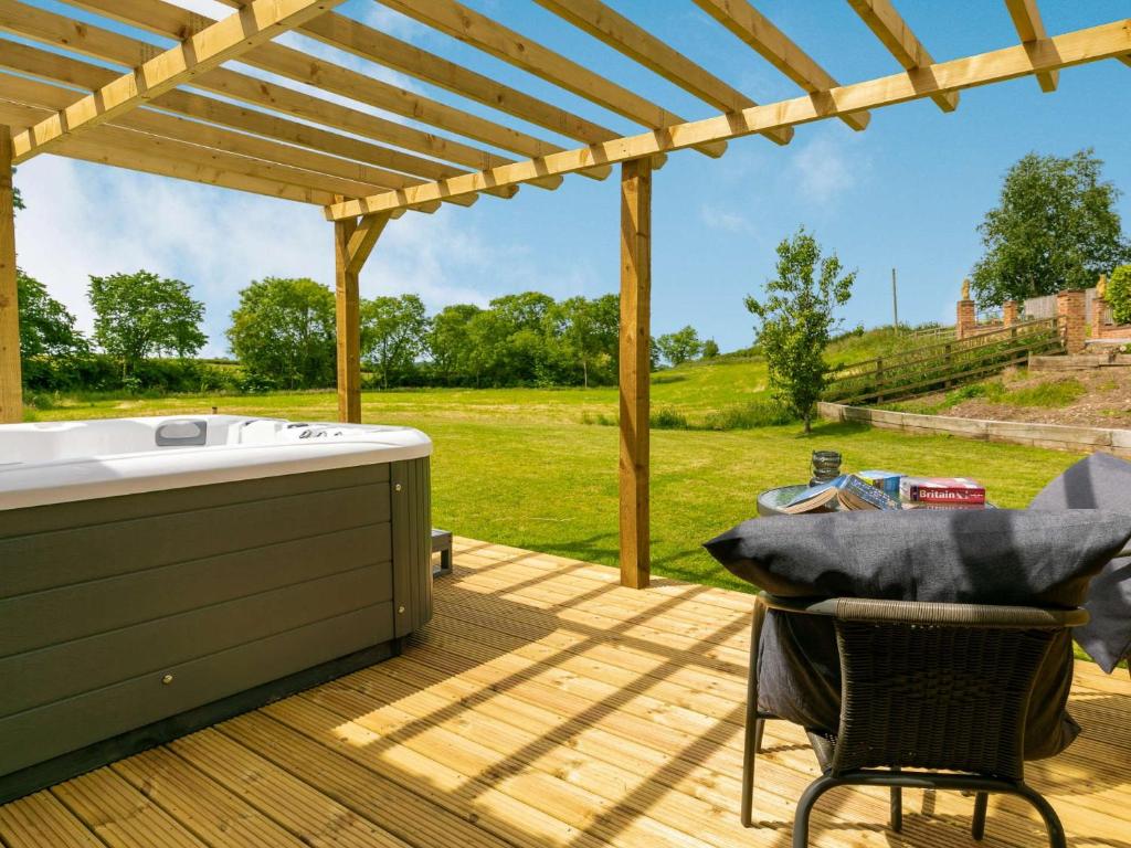 una terraza con bañera de hidromasaje y pérgola en 1 Bed in Malton 88457 