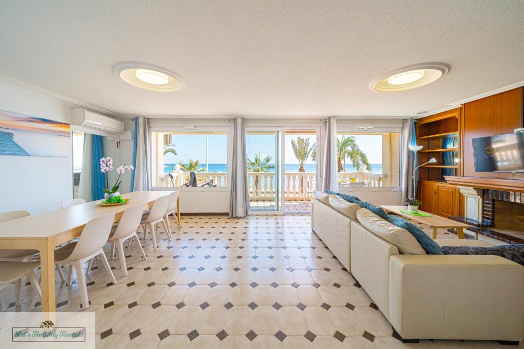 een woonkamer met een witte bank en een tafel bij Apartment front line Jakarta 1 Sea View in El Campello