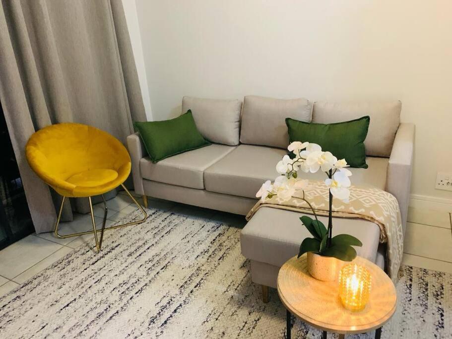 a living room with a couch and a yellow chair at Stylish space Green Creek Estate next to The Blyde in Pretoria