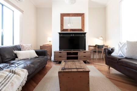 un soggiorno con divano e TV a schermo piatto di Funky Heritage Home in the City Center a Launceston