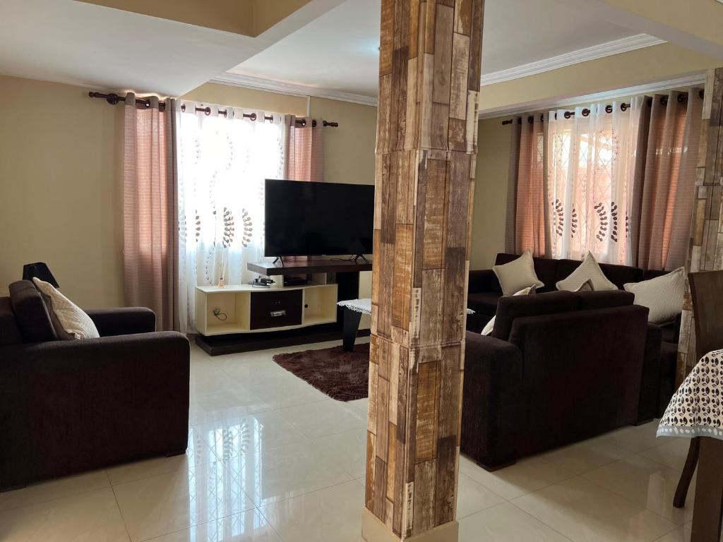 a living room with couches and a flat screen tv at Hermosa y cómoda casa en Cochabamba in Cochabamba