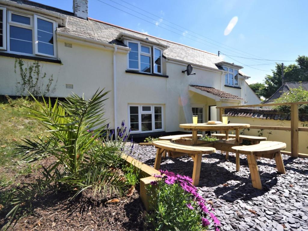 a patio with two picnic tables in front of a house at 2 bed in Braunton 83730 in Barnstaple