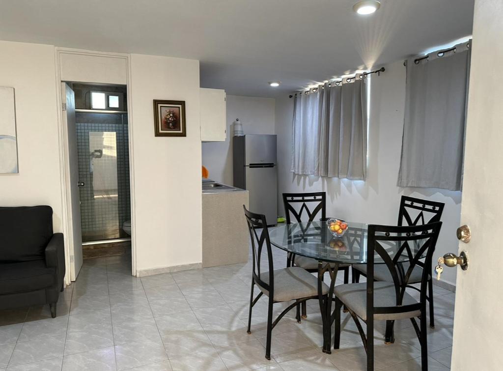a dining room with a table and chairs and a kitchen at Apto comodo, muy cerca de playa 101 in Mazatlán