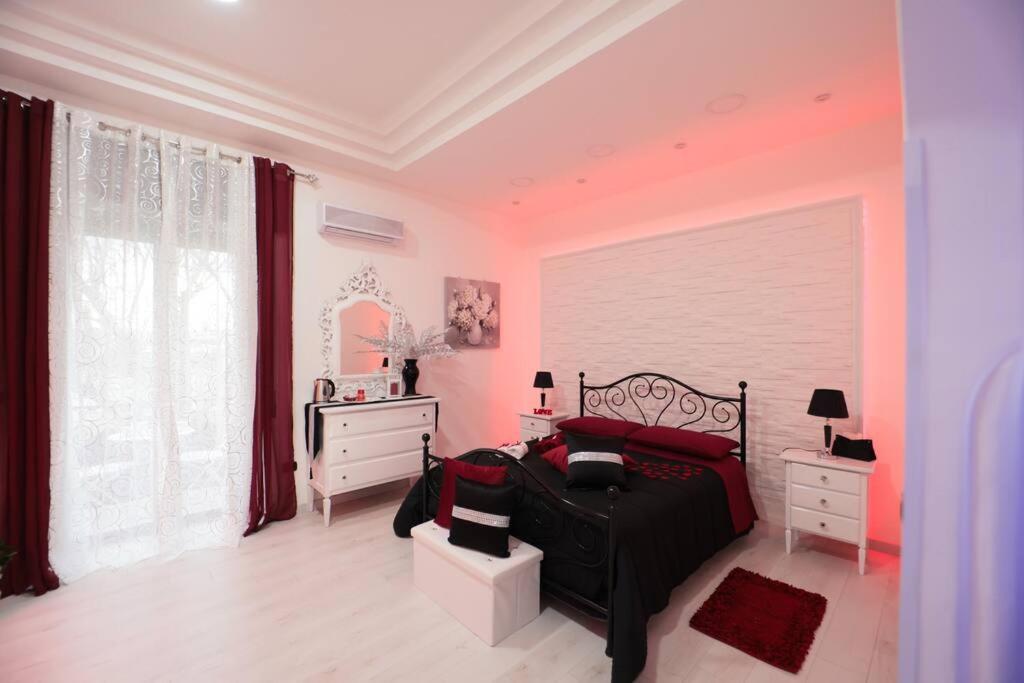 um quarto com uma cama preta e uma cómoda branca em B&B Imperial House in Pompei em Scafati