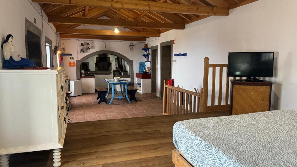 um quarto com uma cama e uma sala de estar com uma cozinha em Casa da Lapa em Angra do Heroísmo