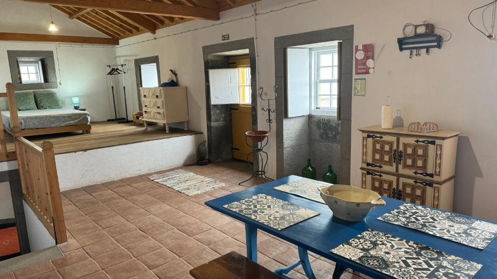 a living room with a table and a bedroom at Casa da Lapa in Angra do Heroísmo