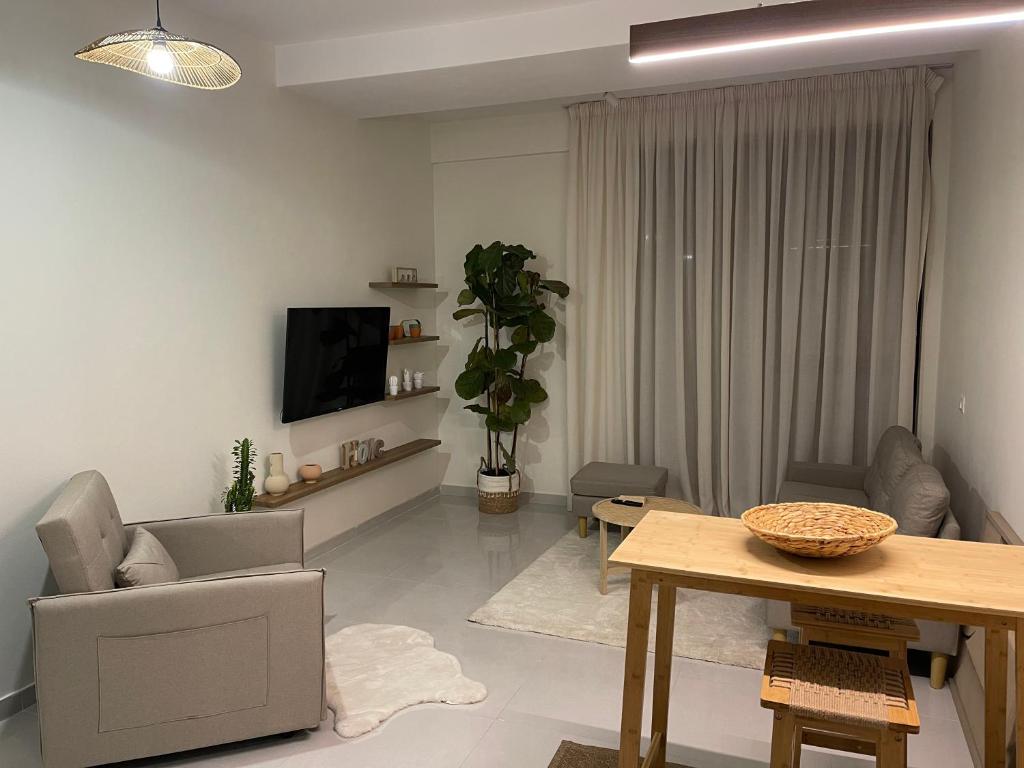 sala de estar con mesa y TV. en Boho Apartment, city center, en Tirana