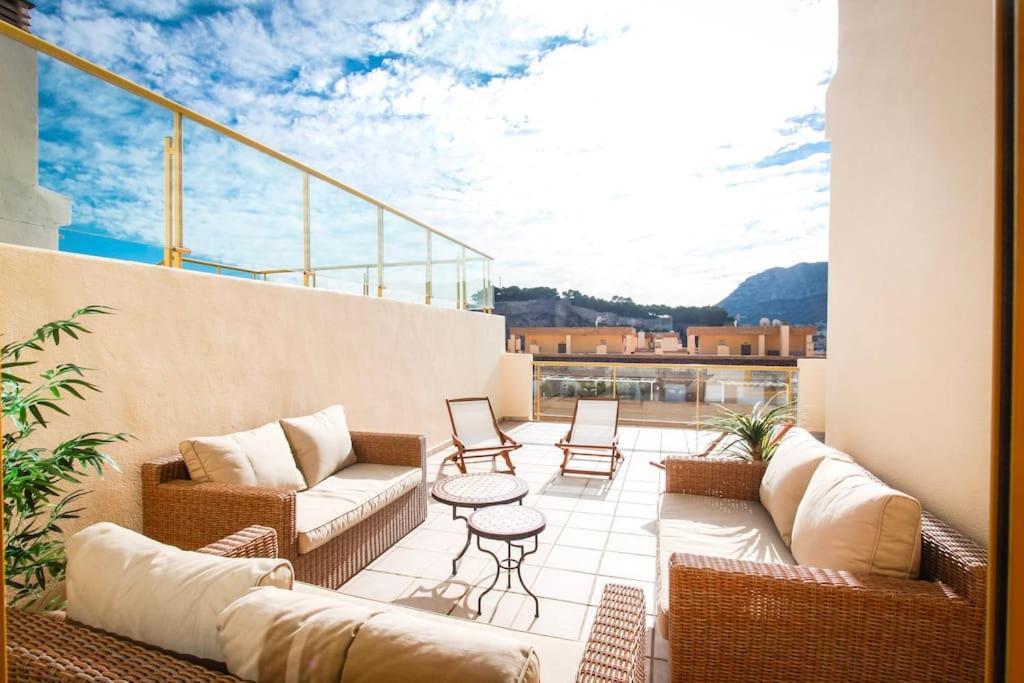 a balcony with couches and a table and chairs at Atico dúplex playa raset by costablancarent in Denia