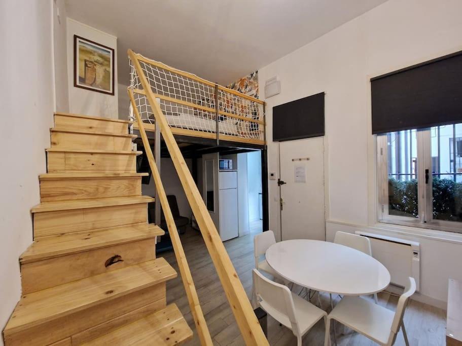 a living room with a staircase and a white table at Mediodia Chica apartamento tipo loft en La Latina in Madrid