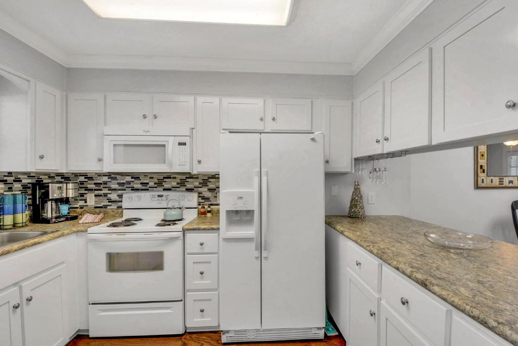 a kitchen with white cabinets and a white refrigerator at Courtyard Villa B-2 in Saint Simons Island