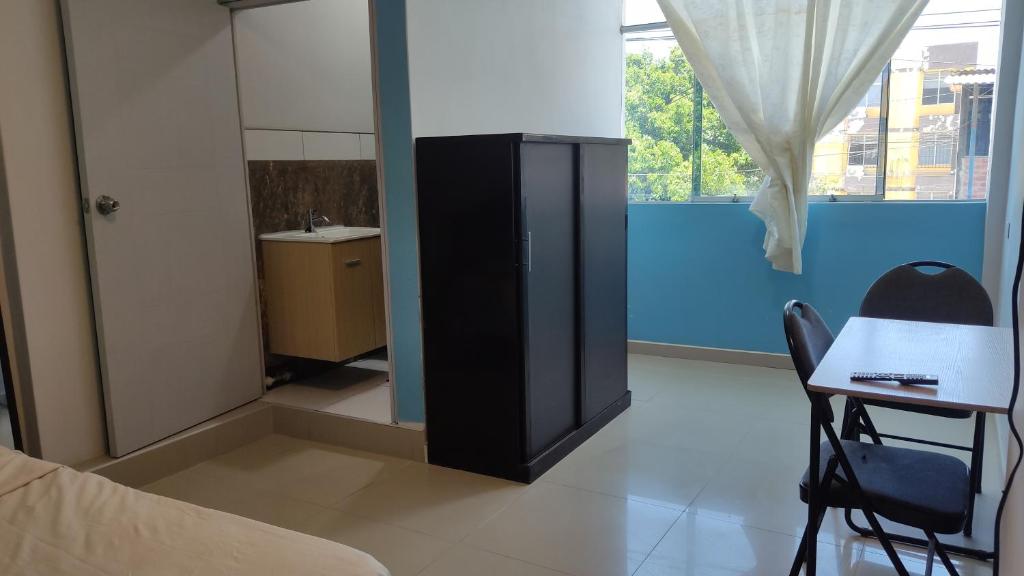 1 dormitorio con cama, escritorio y espejo en Condominio Confortable, en Talara