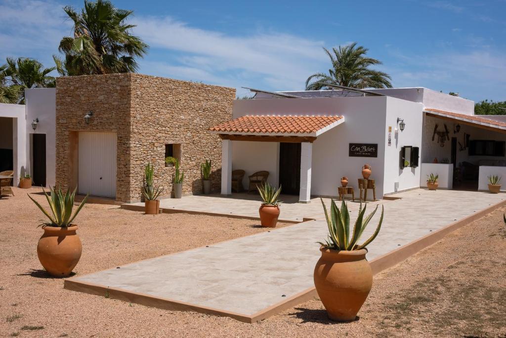 a house with potted plants in front of it at Casa Rural Can Blaiet in La Mola