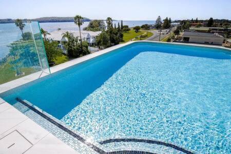 una gran piscina azul con vistas al océano en Elegant 2-Bed Apartment with Stunning Views, en Batemans Bay