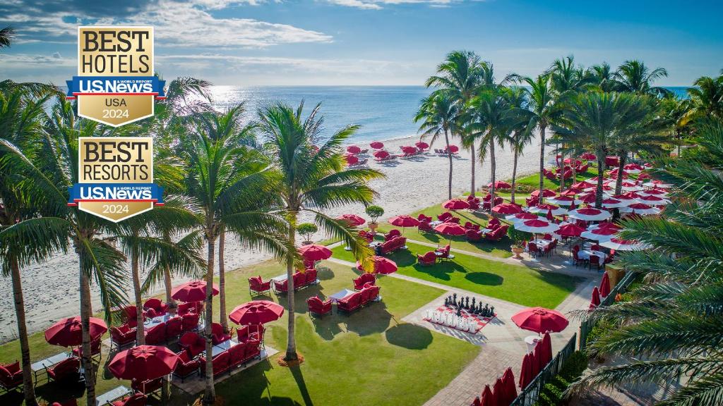 マイアミビーチにあるAcqualina Resort and Residencesの赤い傘とビーチを備えたリゾートのオーバーヘッドビュー