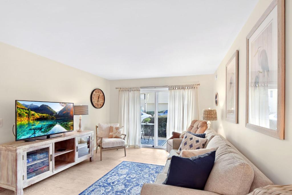 a living room with a couch and a flat screen tv at Ocean Walk E-5 in Saint Simons Island