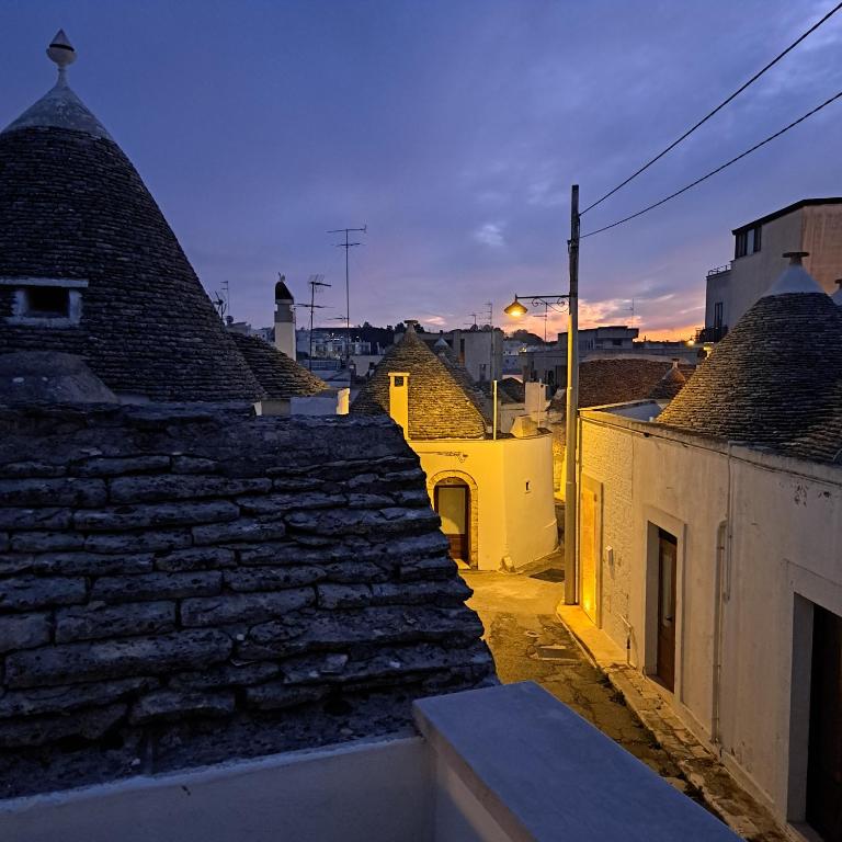 une vue depuis les toits des bâtiments du crépuscule dans l'établissement Il trullo del Guelfo, à Alberobello