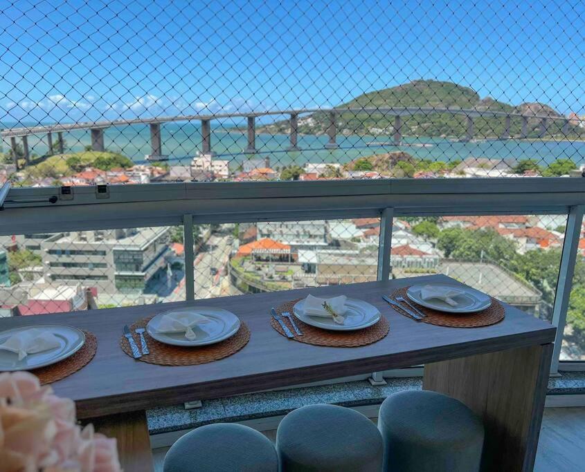 a table with hats and plates on top of a balcony at Apartamento com vista para o mar in Vitória