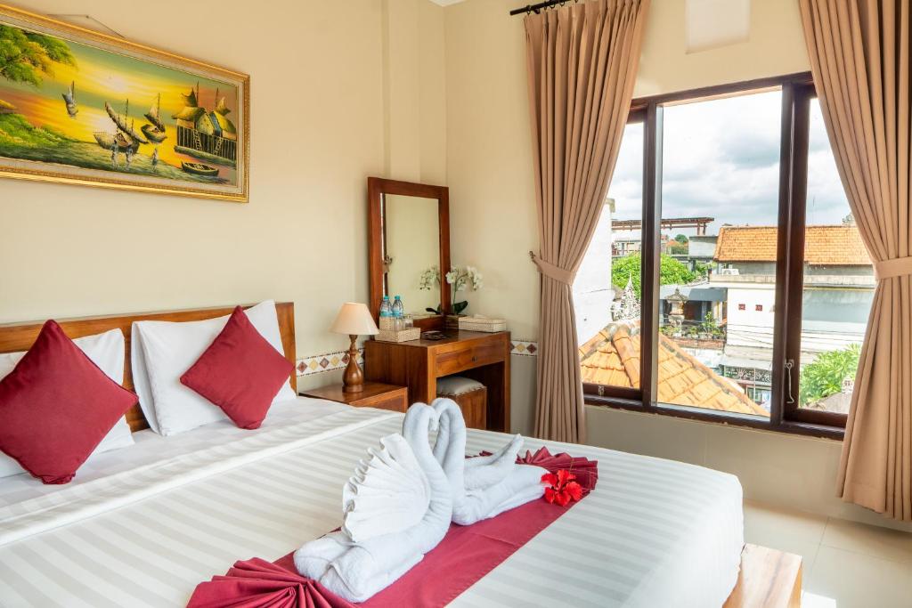 a hotel room with two beds with towels on them at Rama House in Ubud