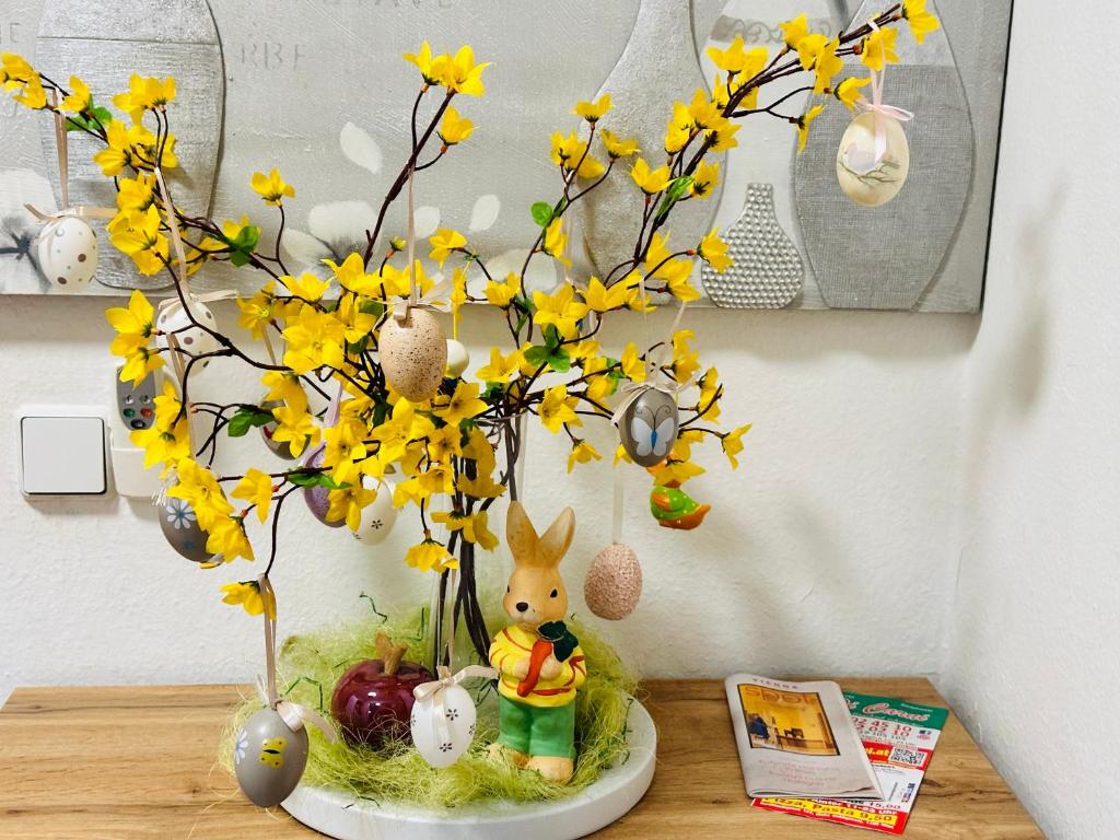 eine Vase voller gelber Blumen auf einem Tisch in der Unterkunft Family - Room in Wien