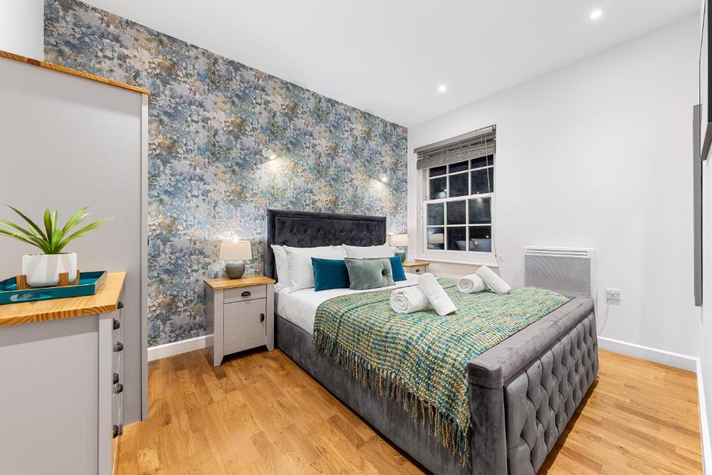 a bedroom with a large bed and a window at Modern One Bed Apartment - Sleeps 3 - Near Heathrow, Windsor Castle, Thorpe Park - Staines London TW18 in Staines upon Thames