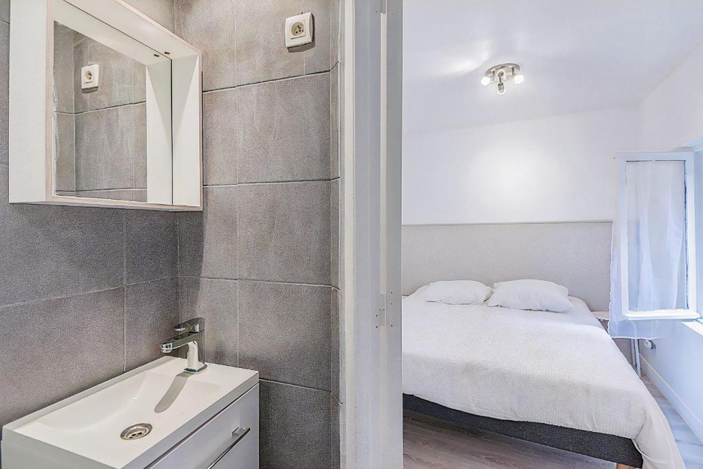 une petite salle de bain avec un lavabo et un lit dans l'établissement Petit Nid Douillet in the Old Port, à Marseille