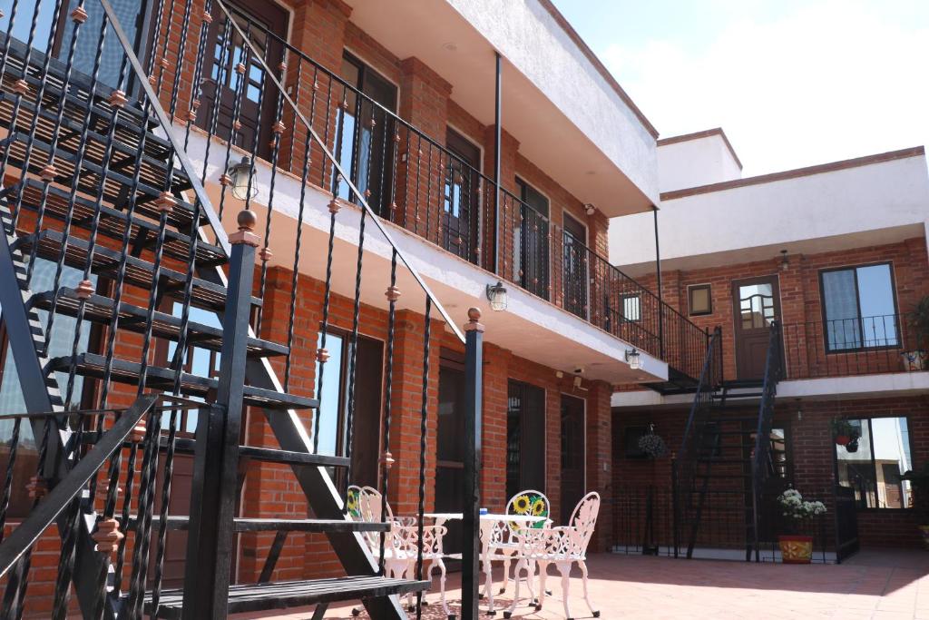 Alojamiento HM في تشولولا: مبنى به درج وطاولات وكراسي