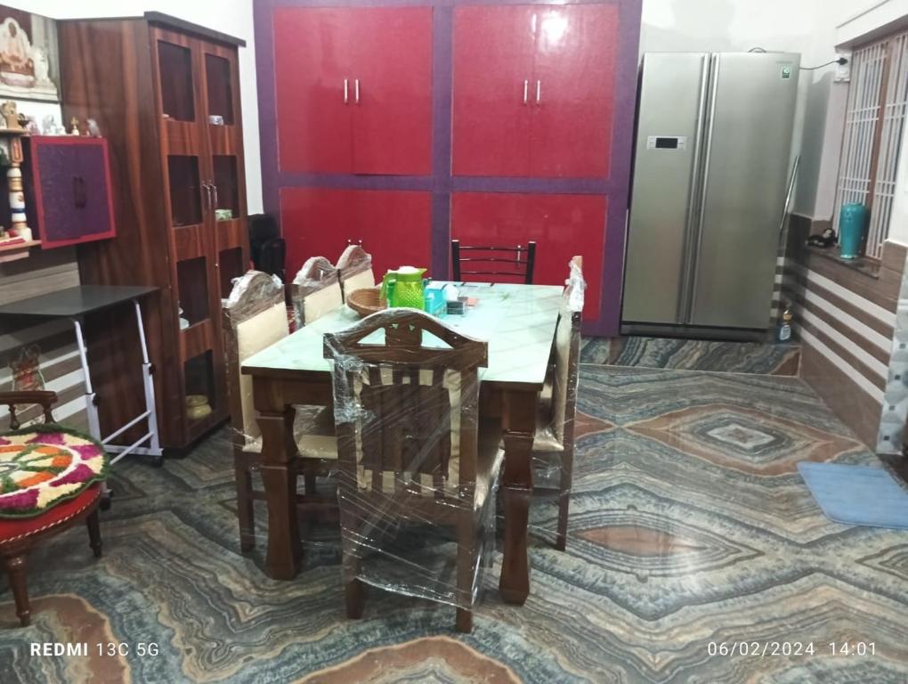 a kitchen with a table and chairs and a refrigerator at RADHA NIVAS in Govardhan