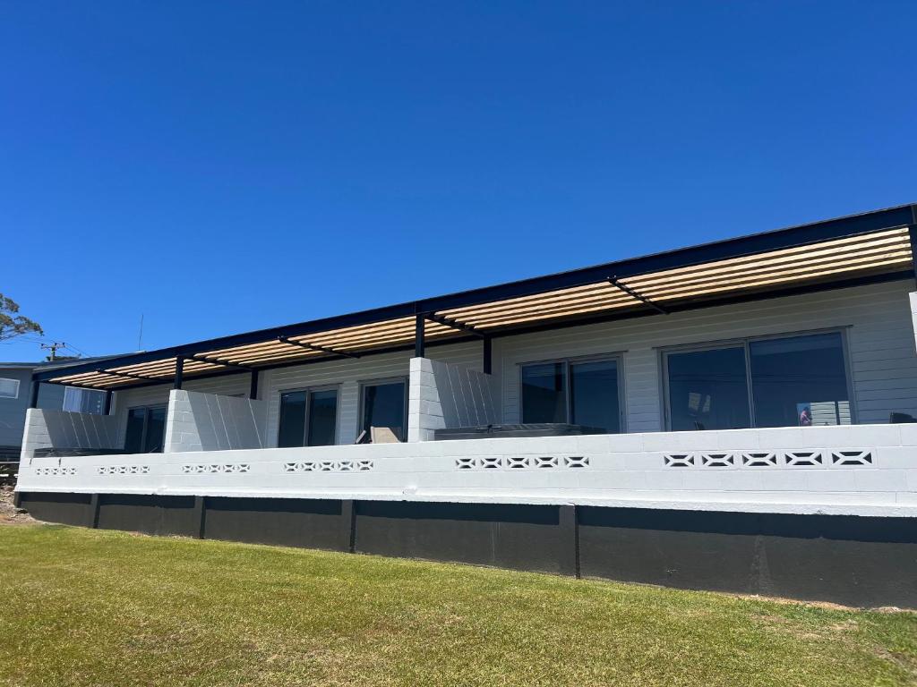 a building with a fence in front of it at Ranui Lodge in Mangonui