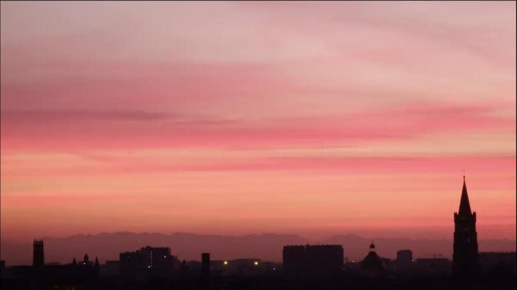 a city skyline at sunset with a pink at Chambre & table d'hôte à 5 min de la gare Matabiau in Toulouse