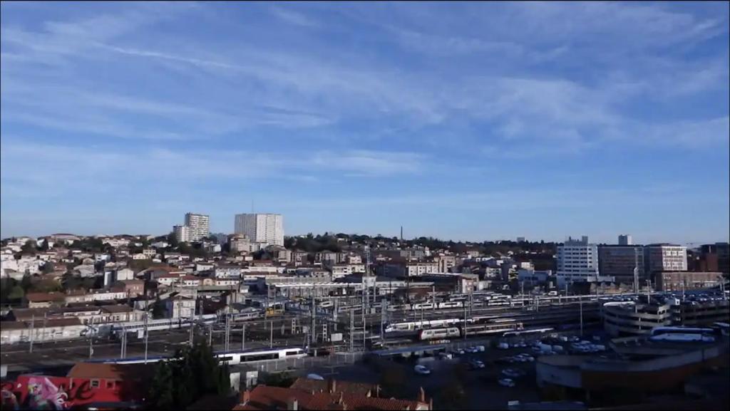 a view of a city with buildings and cars at Chambre & table d'hôte à 5 min de la gare Matabiau in Toulouse