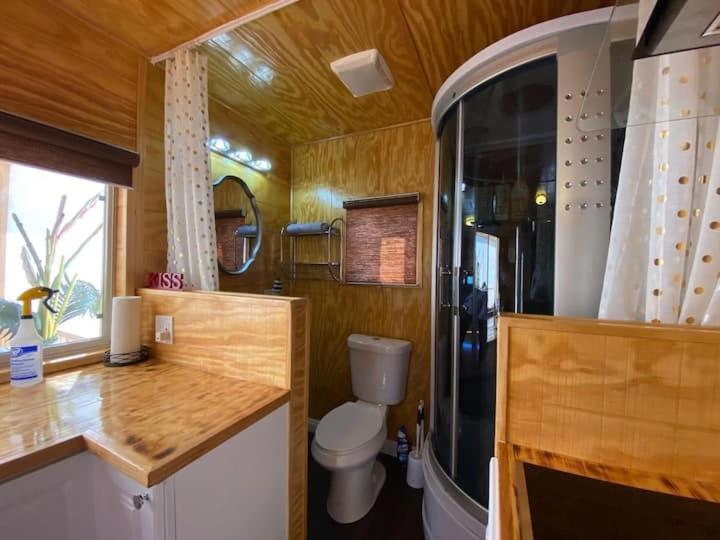 a bathroom with a toilet and a shower in a train at Sun Tiny House A Pahrump in Pahrump