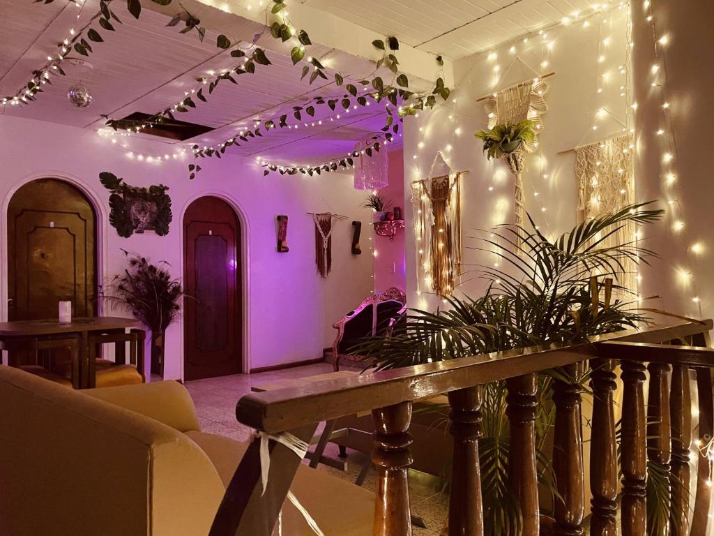 Habitación con iluminación púrpura y mesa con planta en Hotel Boutique Tesoro, en Sevilla