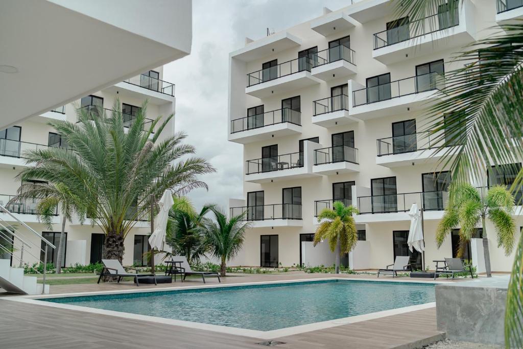 uma vista exterior de um hotel com uma piscina e palmeiras em Downtown Punta Cana, Republica Dominicana. em Punta Cana