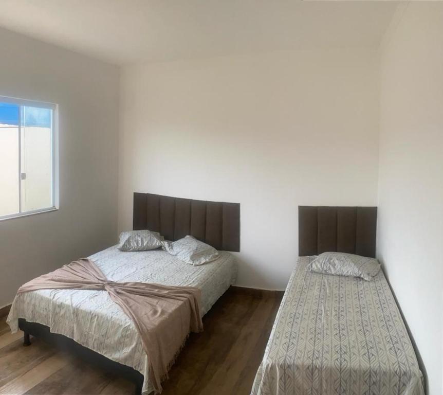 een slaapkamer met 2 bedden en een raam bij Residencial linda vista casa azul in Mateus Leme