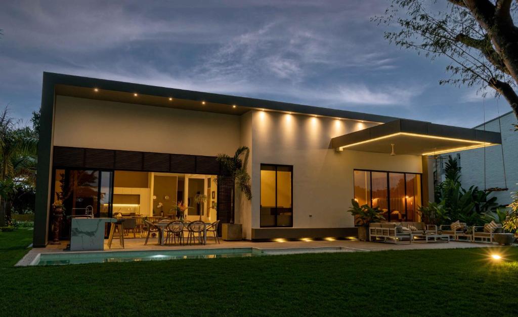 Una casa con luces en el costado. en Casa con Lago y Campo de Golf, en Santander de Quilichao