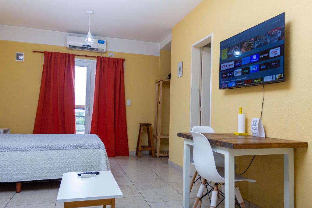 Habitación con cama, mesa y TV. en Un lugar cómodo y céntrico en General Sarmiento