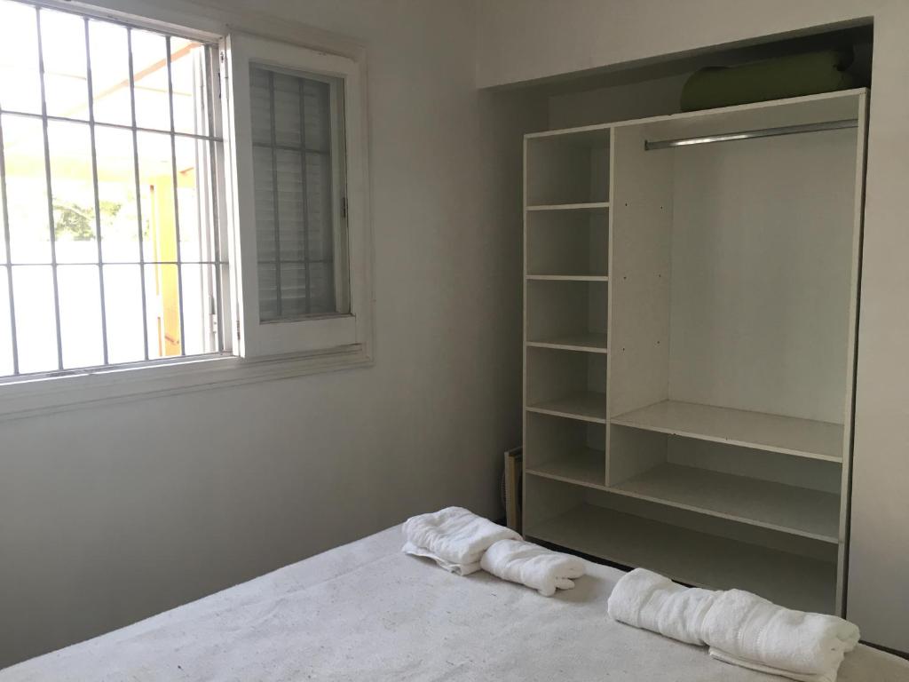 ein Schlafzimmer mit einem Bett, einem Fenster und Regalen in der Unterkunft Silvestre in Mar del Plata