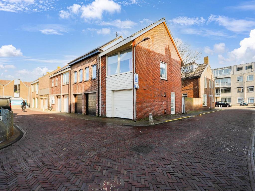 um edifício de tijolos com garagem numa rua em Vacation home 450 m from the beach em Katwijk aan Zee