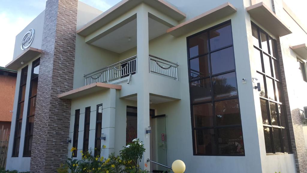 a house with a balcony in front of it at HOTEL BNL in Kalibo