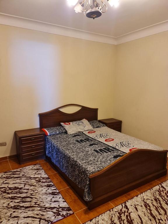 ein Schlafzimmer mit einem Bett in einem Zimmer mit einem Teppich in der Unterkunft برج العزيزية بانوراما بحر للعائلات فقط in Alexandria