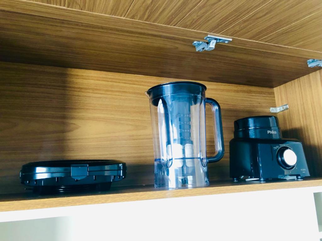 a blender and a camera on a shelf at Casa com piscina exclusiva in Cabo Frio
