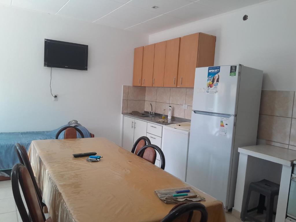 a kitchen with a table and a white refrigerator at Bragado Apart in Bragado
