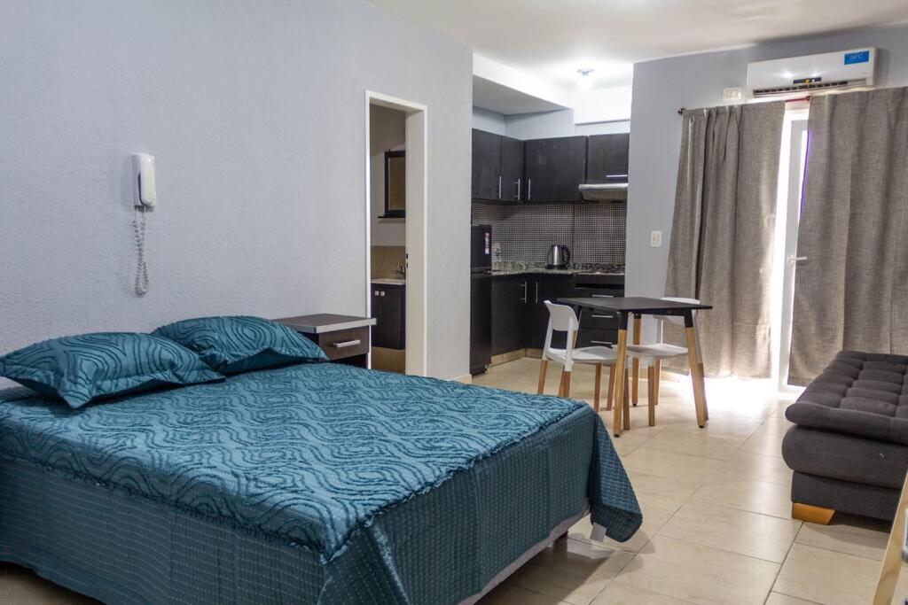 1 dormitorio con cama, mesa y cocina en Buena ubicación de monoambiente en General Sarmiento