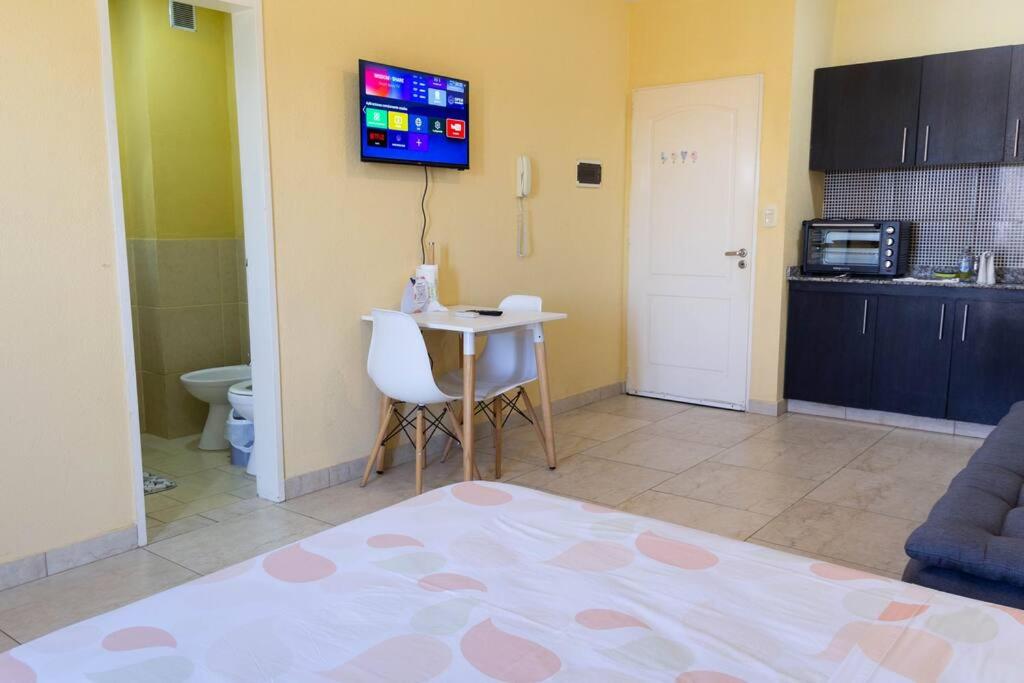 eine Küche mit einem Tisch und einem TV an der Wand in der Unterkunft Bello departamento en San Miguel in General Sarmiento