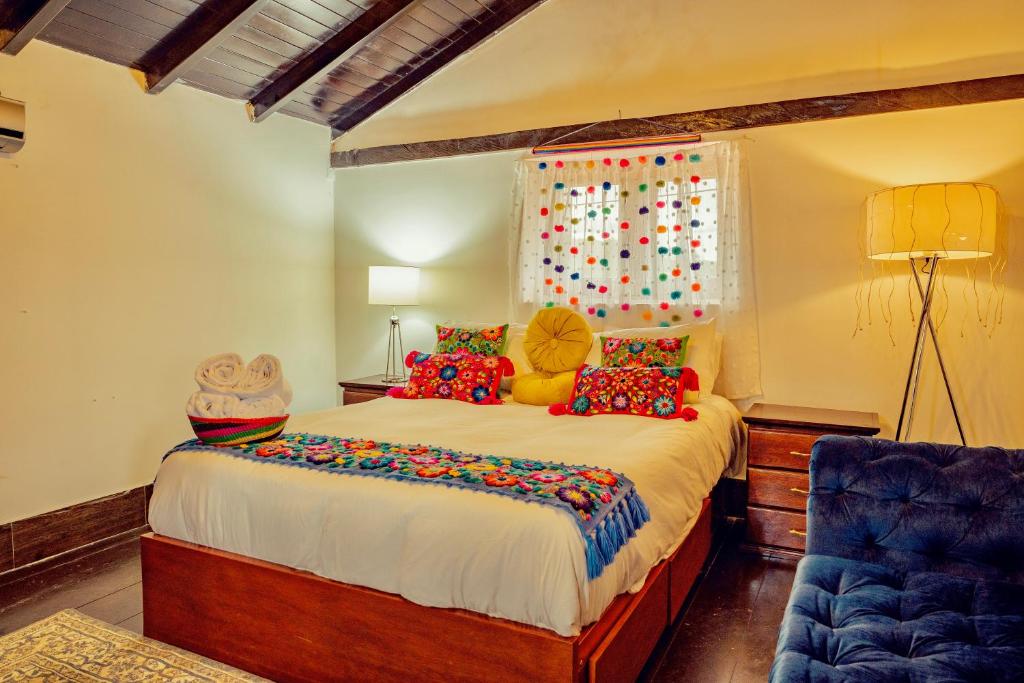 a bedroom with a large bed and a blue chair at Colonial Home Chachapoyas in Chachapoyas