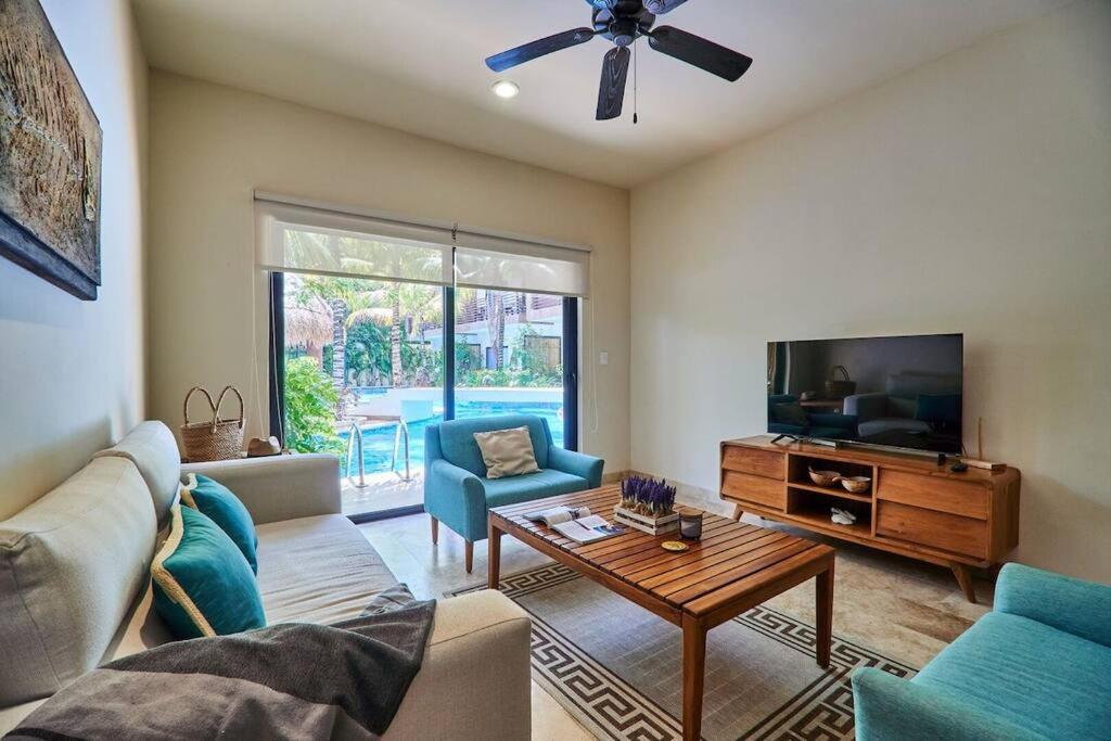 a living room with a couch and a tv at Zen Oasis Swim Up Condo Pool W Tiki Hut Bar + Gym in Tulum