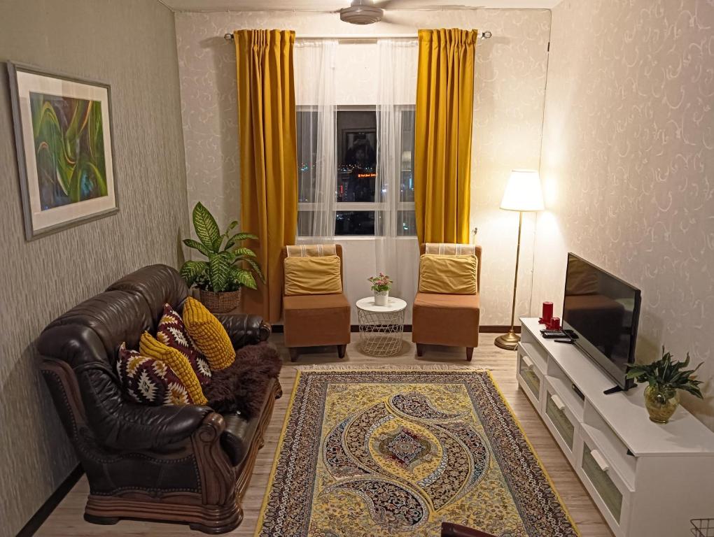 クアラ・トレンガヌにあるSky Palace Kuala Terengganuのリビングルーム(革張りのソファ、テレビ付)