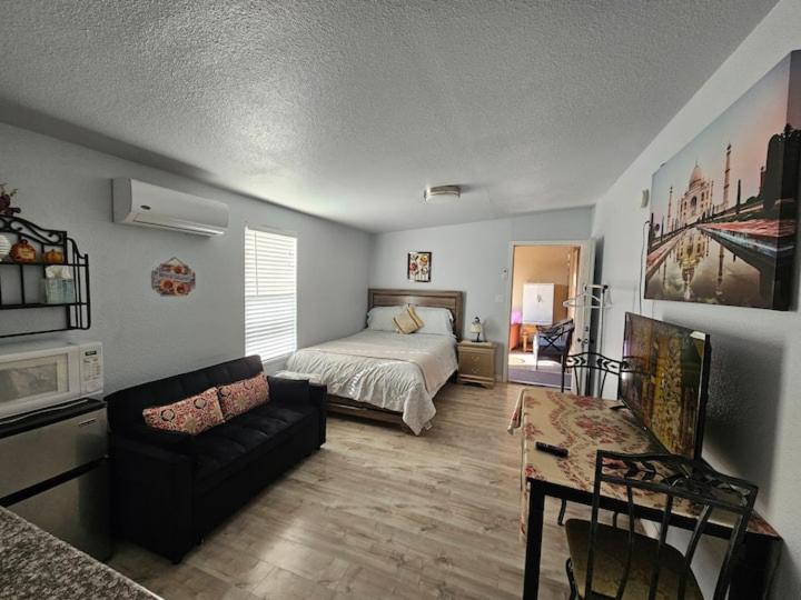 a bedroom with a bed and a couch and a table at Sun Guest House Pahrump in Pahrump